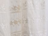 an old white dress hanging on a hanger in a room
