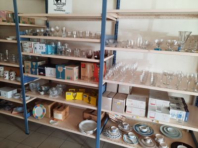 une étagère sur laquelle sont disposés de nombreux objets en verre, dans une pièce