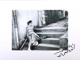a black and white photo of a woman sitting on the steps
