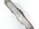 a silver and wood hair clip on a white surface