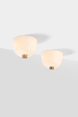 a pair of white and gold sconces on a white surface