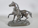 statue en bronze représentant un cheval et son cavalier sur fond blanc