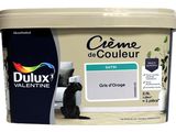 un gros plan sur un pot de peinture, avec un chat assis par terre