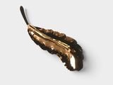 a gold spoon with a black handle sitting on a white surface