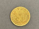 a close up of a gold coin with a crown on it