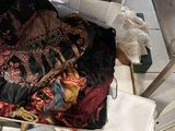 a pile of clothes on the floor next to a table