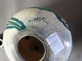a white vase with a green and black design on it