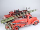 un camion de pompiers rouge avec tout un tas d'arbres à l'arrière