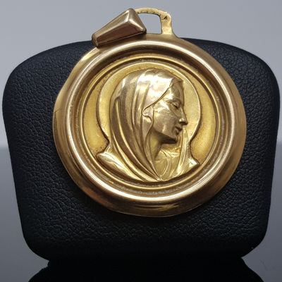 l'image d'une médaille d'or sur laquelle figure le visage d'une femme