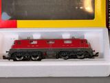 a red and black train on display in a box