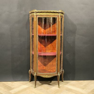 une vitrine ancienne dotée d'une porte vitrée et d'une étagère en bois