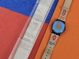 une montre posée à côté d'un bout de papier