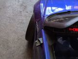 a blue car with luggage in the trunk of it