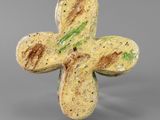 a close up of a cross shaped object on a gray surface