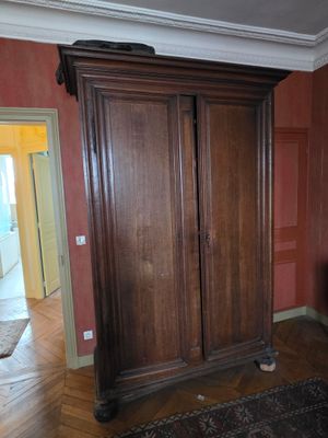 une grande armoire en bois dans le coin d'une pièce