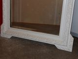 a large white mirror sitting on the floor in a room