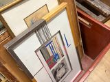 a lot of framed art on the floor in this room