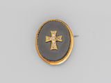 une broche en forme de croix en émail doré et noir, sertie de diamants