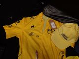 a yellow shirt and a hat sitting on a black suitcase
