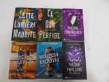 six livres de poche d'une série posés sur une table blanche