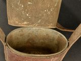 an old bucket with a handle on a black table