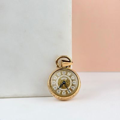 une montre de poche ancienne en or, avec des chiffres romains sur le cadran