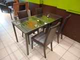 a glass table and chairs in a room with green walls