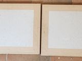 two picture frames sitting on the floor next to each other