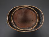 brown and black bowl on a black surface with a black background