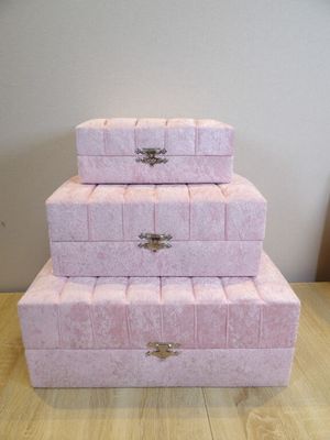trois boîtes roses empilées les unes sur les autres sur une table