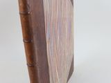 un livre marron avec une couverture marron et une étiquette rouge dessus