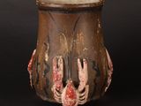 a brown vase with red and black designs on it