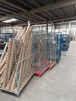 de nombreux rouleaux de bois sur un chariot dans un entrepôt