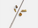 un gros plan d'une aiguille et d'autres objets posés sur une surface blanche