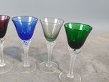 four wine glasses are lined up in a row on a table