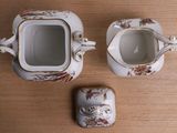 a tea pot and a cup sitting on a table