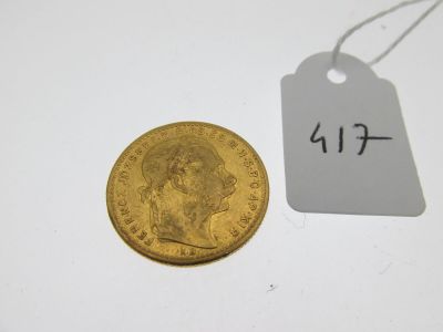 un gros plan d'une pièce d'or à côté d'une étiquette de prix