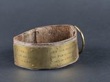 un gros plan d'un bracelet en laiton sur lequel figure une inscription