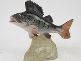 figurine of a fish on a rock on a white background