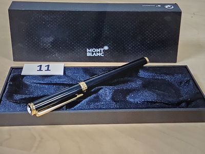 un stylo noir dans une boîte noire posée sur une table