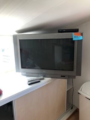 a television and a trash can in the corner of a room