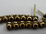 a close up of a bunch of gold colored beads on a white surface