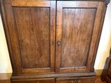 une armoire en bois surmontée de deux tiroirs