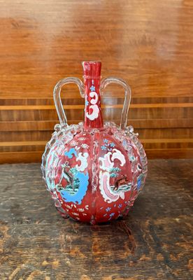 un vase rouge posé sur une table en bois