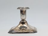 an image of a silver candle holder on a white surface