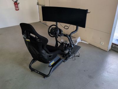 une photo d'un simulateur de course automobile dans un garage