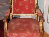 a red and gold chair in a room with a rug