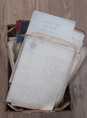 une boîte remplie de vieilles lettres et de vieux papiers posée par terre