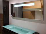 une salle de bains équipée d'un lavabo, d'un miroir et d'un extincteur