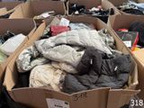 de nombreux cartons remplis de vêtements qui traînent par terre